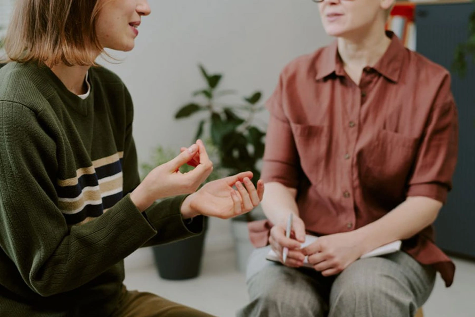 Zwei Frauen im Gespräch, von der Schulter abwärts Zwei Frauen im Gespräch, von der Schulter abwärts