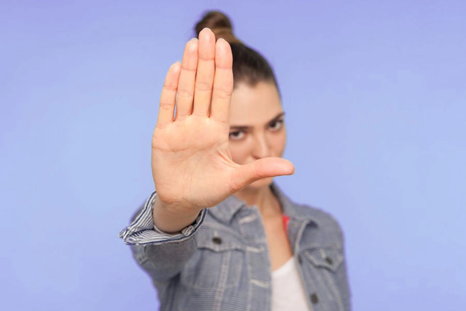 Frau hält ihre Hand in die Luft und signalisiert damit: Stop! Frau hält ihre Hand in die Luft und signalisiert damit: Stop!