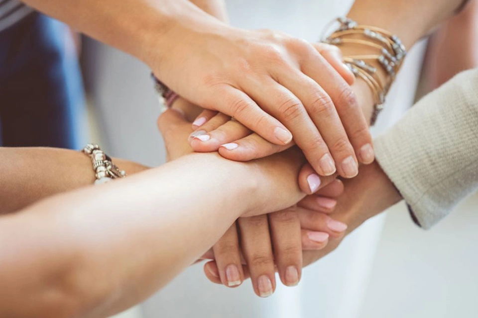 Hände unterschiedlicher Frauen liegen übereinander Hände unterschiedlicher Frauen liegen übereinander