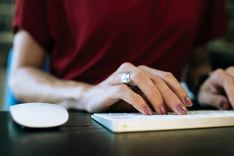 Frauenhand tippt auf einer Computertastatur Frauenhand tippt auf einer Computertastatur
